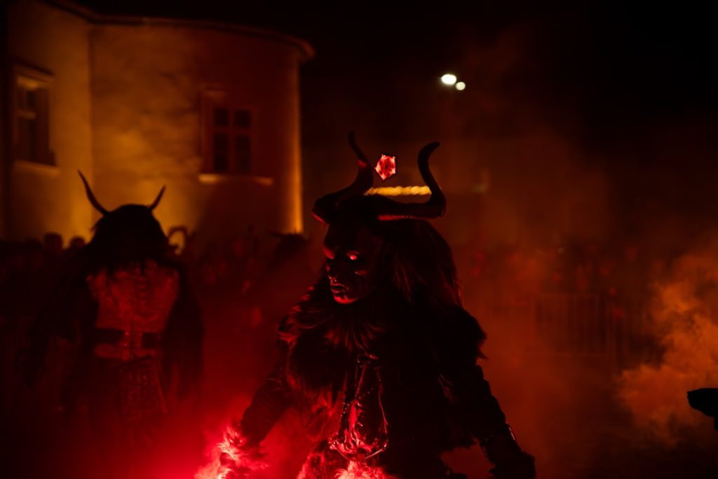 costumed-figures-with-horns-and-glowing-eyes-at-night-faau5898c6k