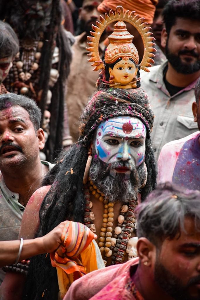 Colorful festival scene with participants in traditional attire and painted faces, celebrating together.